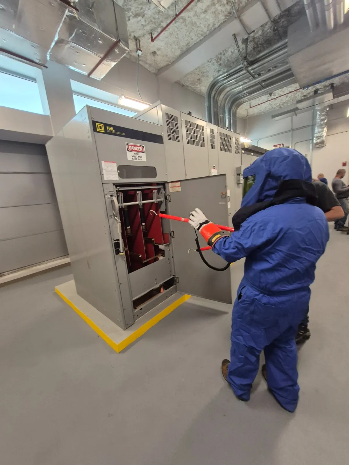 Técnico con equipo de protección arc flash en switchgear